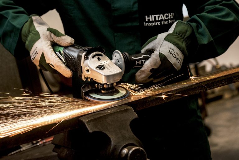 Person Holding Black and Gray Hitachi Angle Grinder